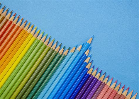 Closeup Of Colored Pencils Lined Up In A Row And Abstract Shape On