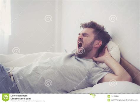 Handsome Young American Male Yawn Sleeping In Bed At Home Stock Photo