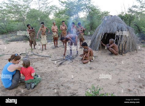 Turists Watching Bushmen Of The San People Singing And Dancing Around Fireplace Kalahari