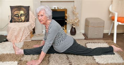 an older woman is doing yoga in her living room