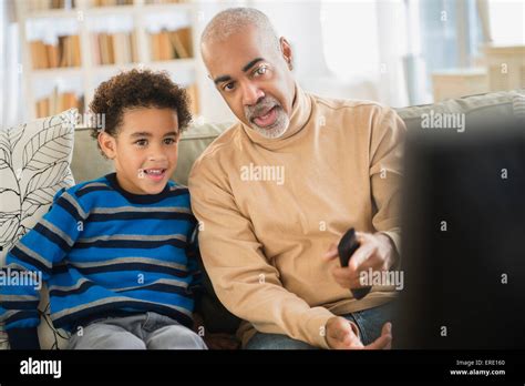Mixed Race Grandfather And Grandson Watching Television Stock Photo Alamy