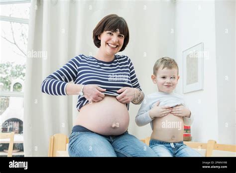 Portrait Of Pregnant Mother And Son Showing Bellies Stock Photo Alamy