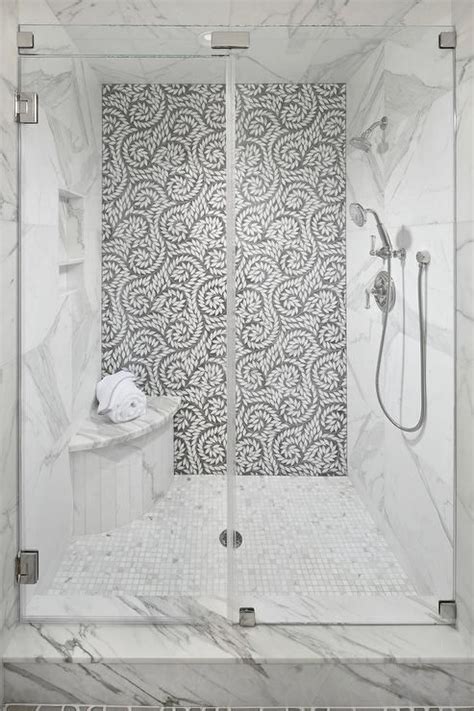 A Seamless Glass Walk In Shower Boasts A Curved Marble Shower Bench