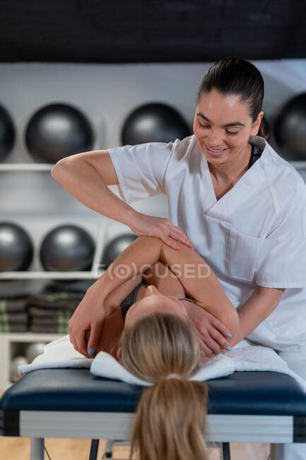 Female Therapist In White Robe Massaging Woman During Osteopathy Session In Clinic — Hospital