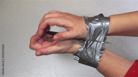 Trying To Tear Duct Tape And Escape From Tied Hands Survival Concept Female Holds A Knife And