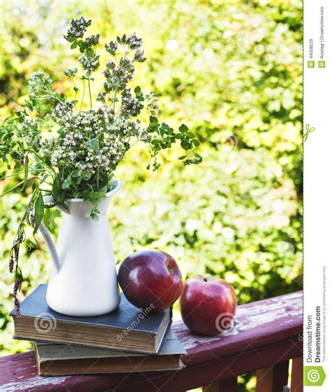 Summer Wild Flowers In Glass Vase Old Books And Apples Stock Image