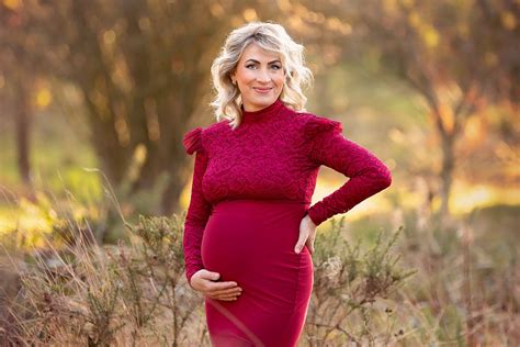 Beautiful Blond Pregnant Woman In A Stunning Red Gown Posing For A