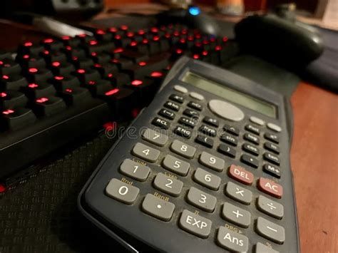 Scientific Calculator Over A Computer Keyboard On A Wooden Desk Stock