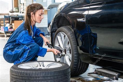 Female Mechanic Changing Car Tire Stock Photo By ©corepics 125218578