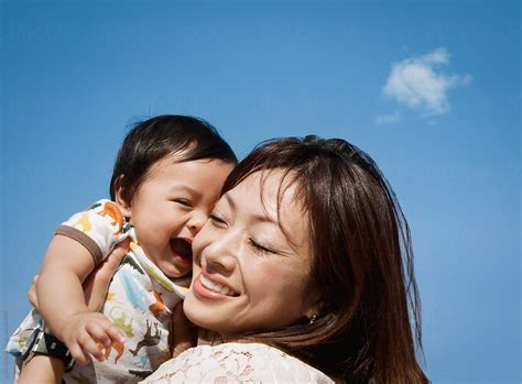Happy Asian Mother And Baby Boy In Blue Sky By Stocksy Contributor