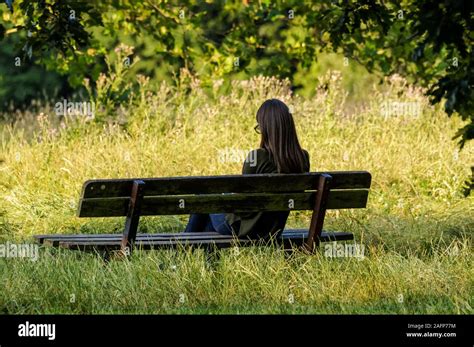 junge frau sitzt auf der parkbank fotos und bildmaterial in hoher auflösung alamy