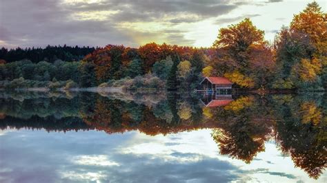 Colorful Autumn Fall Leafed Trees And House Reflection On Calm Body Of