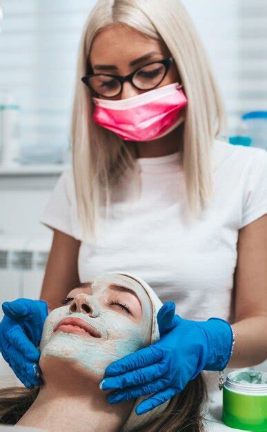 Premium Photo Beautiful Young Woman Receiving Facial Mask With Rejuvenating Effects In Spa