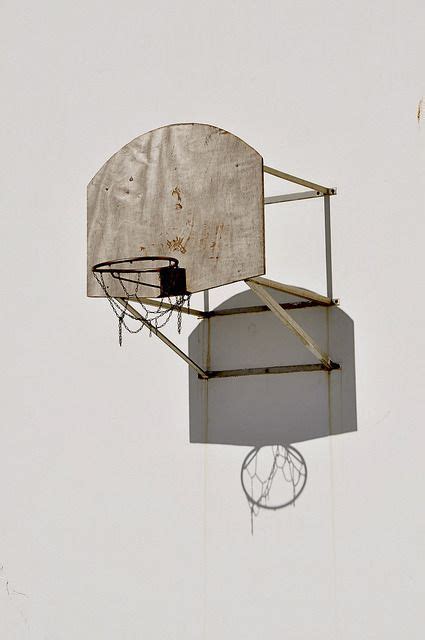 An Old Basketball Hoop Hanging From The Side Of A Building