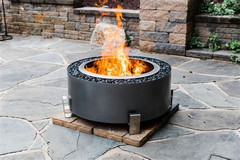 A Fire Pit Sitting On Top Of A Stone Patio