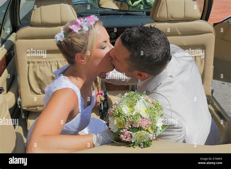 La Novia Y El Novio Besándose En El Asiento Trasero De Un Coche Abierto Convertible Fotografía