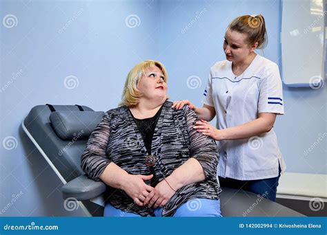 Young Inexperienced Female Doctor Taking Care of a Fat Sick Woman on
