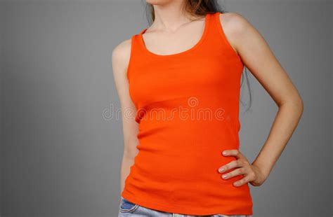 a girl in a orange plain t shirt empty tank top closeup isolated on grey background stock