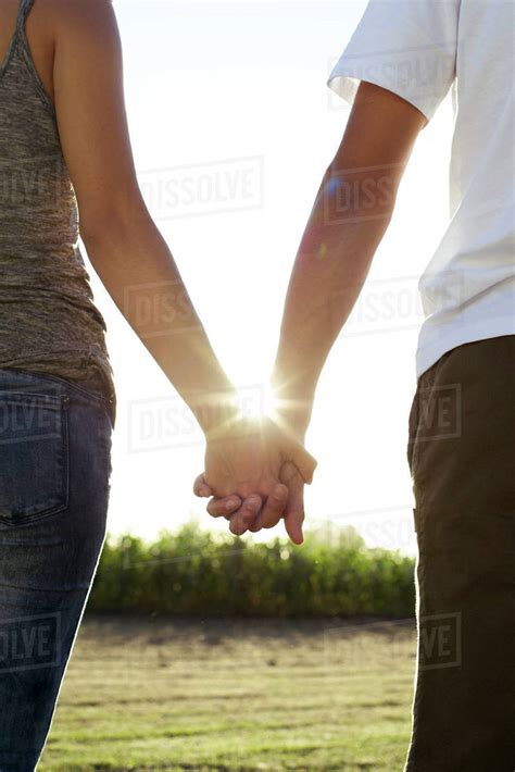 Two People Walking Together Holding Hands