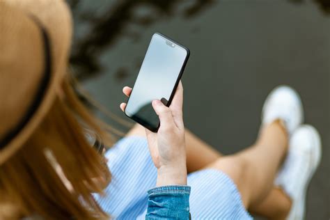 Person Holding Smartphone White Sitting · Free Stock Photo