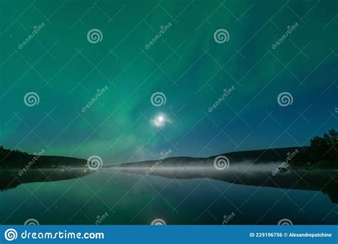 Aurora Borealis Northern Green Lights With Full Moon And Stars In The