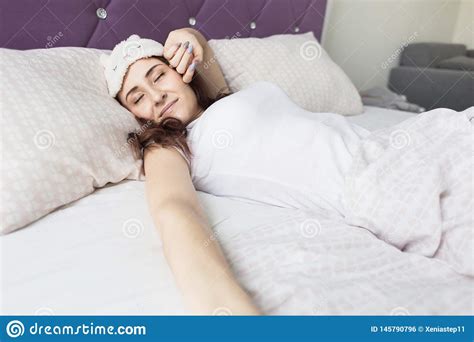 An Attractive Young Brunette Woman Wakes Up In Her Bed In A Sleep Mask