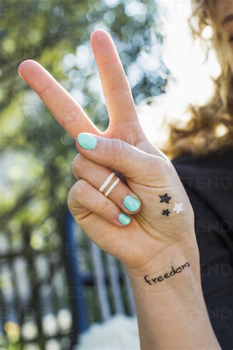 Woman Making Peace Sign With Hand Stock Photo