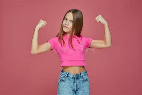 Powerful Sporty Child Girl Show Biceps Muscles Raising Hands On Pink