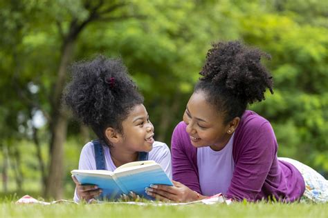 African American mother is teaching her young daughter to read while
