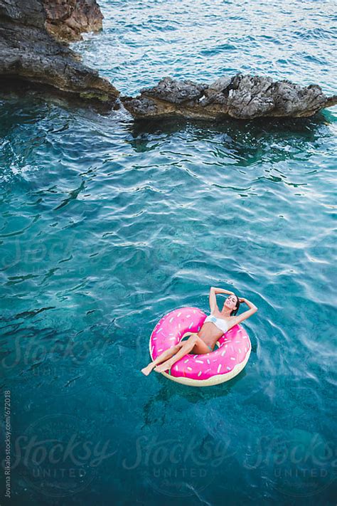 Woman Floating On Inflatable Tube In The Sea By Jovana Rikalo Stocksy