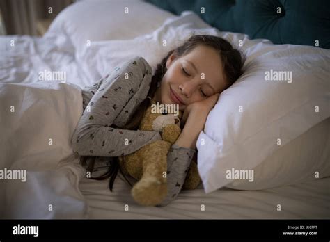 Girl Sleeping On Bed With Teddy Bear In Bedroom At Home Stock Photo Alamy