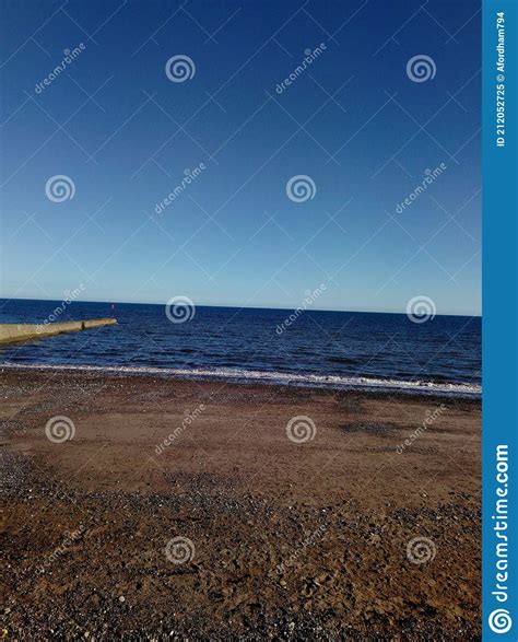 A Shot Of A Clear Summers Sky Over A Deep Blue Ocean Lapping Ashore A