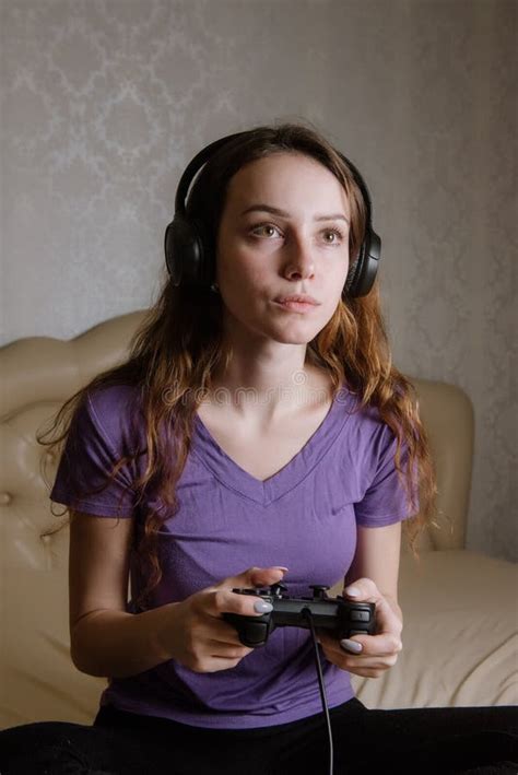 Happy Woman Playing Video Games Sitting On Bed Holding Joystick Stock