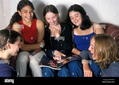 Group Of Teenage Girls Having A Laugh Over A Magazine Article Stock