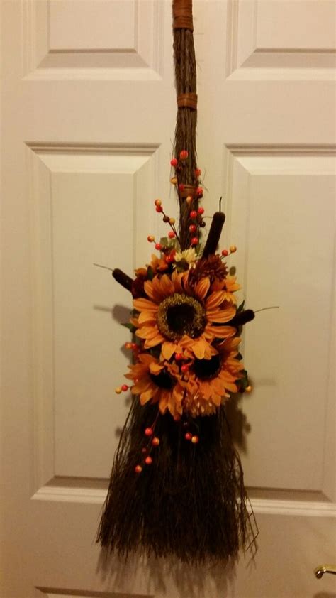 A Broom Decorated With Sunflowers And Berries Hangs On The Front Doors
