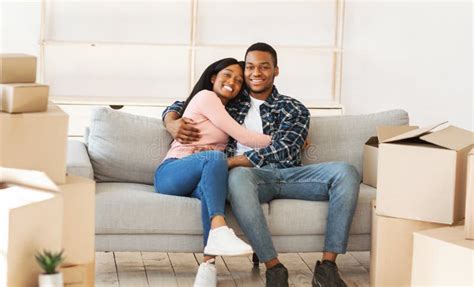 Positive Black Couple Resting On Sofa On Moving Day At Their New Home