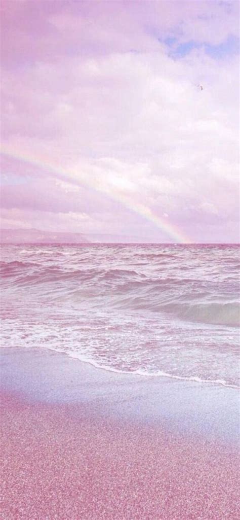 There Is A Rainbow In The Sky Over The Water At The Beach And Its Pink