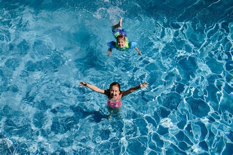 Brother And Sister Having Fun In A Swimming Pool By Jakob Lagerstedt