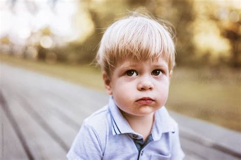 Outdoor Portrait Of A Cute Young Boy With A Sulky Facial Expression