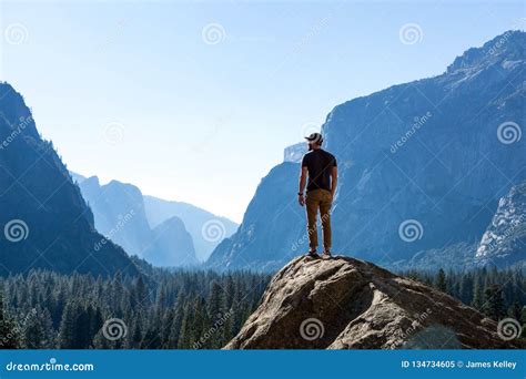Hiker Standing On Top Of Mountain Looking Out At Vast Yosemite National