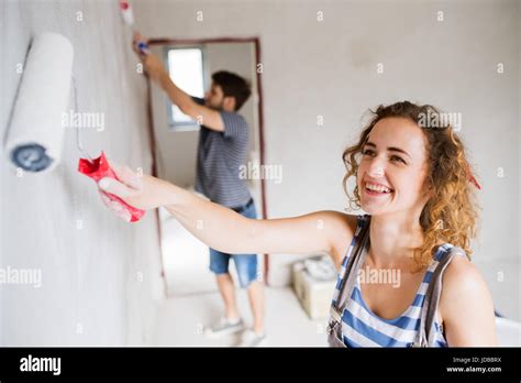 Young Couple Painting Walls In Their New House Stock Photo Alamy
