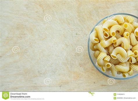 Macaroni Rigati Glass Bowl With Pasta On A Wooden Board With A Side