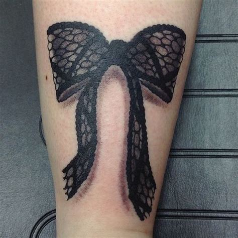 A Womans Leg With A Black Lace Bow Tattoo On Her Left Calf Area