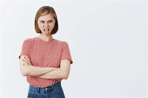 Free Photo Disgusted Young Grimacing Woman Showing Tongue And Complaining Over Something Bad