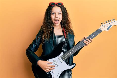 Teenager Hispanic Girl Playing Electric Guitar Celebrating Crazy And