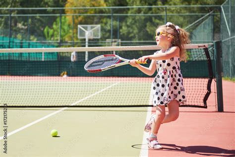 Cute Little Girl Playing Tennis On The Tennis Court Outside Stock Foto