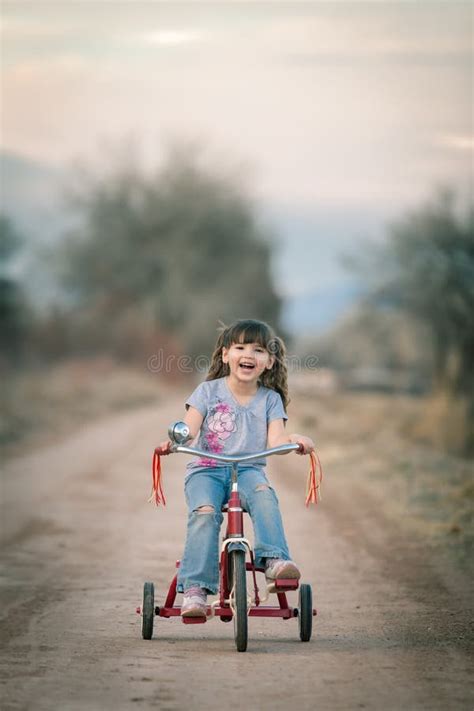 Niña Feliz Que Monta Su Triciclo Imagen De Archivo Imagen De Monta