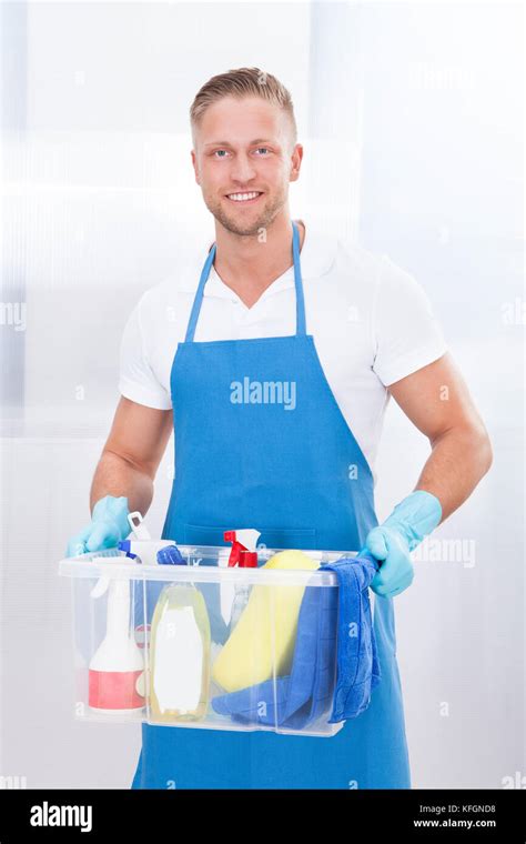 Happy Janitor Or Cleaner Wearing An Apron And Gloves Carrying A Tub Of