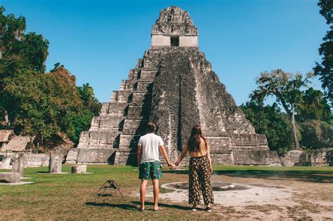 Two People Holding Hands In Front Of An Ancient Pyramid At Chichena Mexico