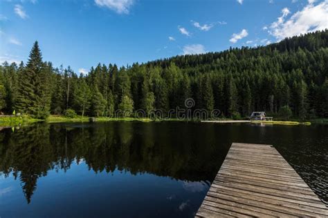 Clear Mountain Lake With A Wooden Jetty In The Forest Stock Photo
